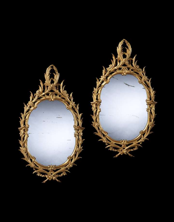 A PAIR OF GEORGE II OVAL GILTWOOD MIRRORS